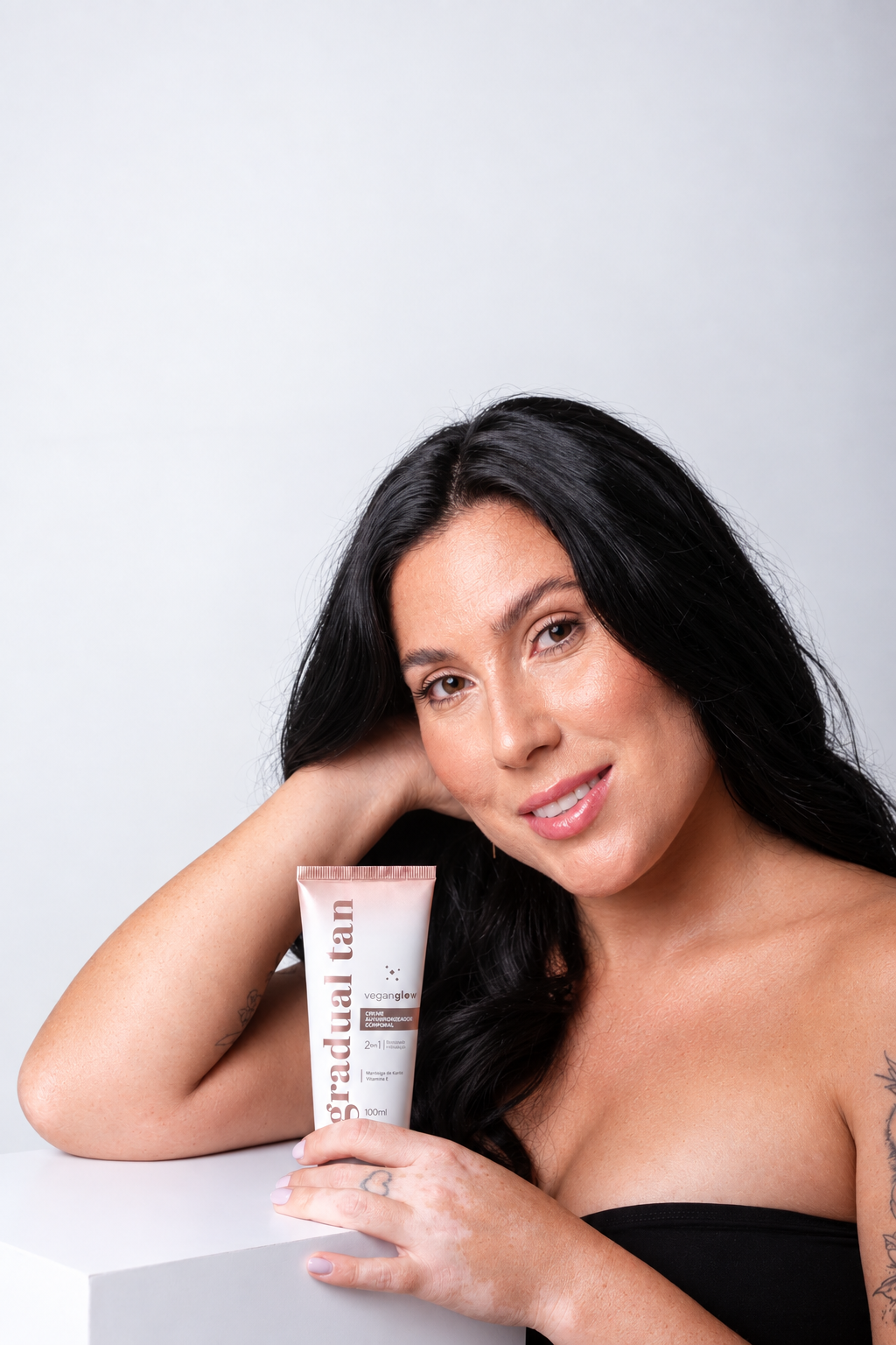Mulher segurando o creme autobronzeador Gradual Tan VeganGlow